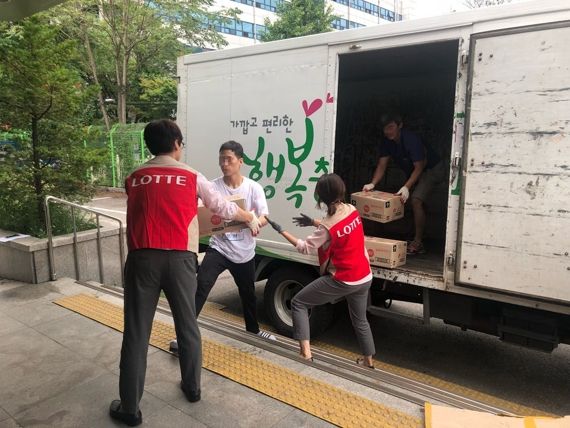 롯데 유통사업부 직원들이 긴급구호물품을 차량에 싣고 있다. 롯데쇼핑 제공.