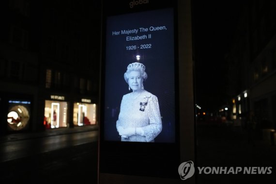여왕 추모 간판 A picture of Britain's Queen Elizabeth II is set up in a London street, Thursday, Sept. 8, 2022, after her death was announced. Queen Elizabeth II, Britain's longest-reigning monarch and a rock of stability across much of a turbulent century, died Thursday after 70 years on the throne. She 