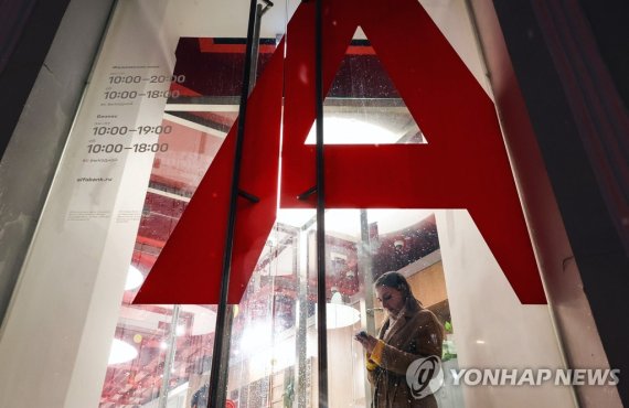 러시아 모스크바 알파은행 지점 MOSCOW, RUSSIA - APRIL 6, 2022: A woman is seen outside an Alfa-Bank office in Neglinnaya Street. The United States sanctions Russia's Sberbank and Alfa-Bank. Sergei Karpukhin/TASS