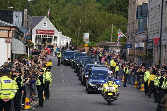 [밸라터=AP/뉴시스] 스코틀랜드 밸라터에서 11일(현지시간) 영국 시민들이 엘리자베스 2세 영국 여왕의 운구 행렬을 보며 고인의 마지막 길을 배웅하고 있다.