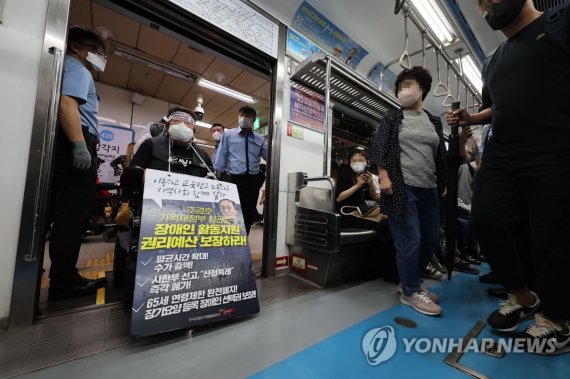 전장연 탑승 시위 계속 (서울=연합뉴스) 류영석 기자 = 30일 오전 서울 용산구 삼각지역에서 전국장애인차별철폐연대 회원들이 장애인권리예산 보장을 촉구하며 삭발투쟁 100일차 맞이 기자회견을 한 뒤 지하철 탑승 시위를 하고 있다. 2022.8.30 /사진=연합뉴스