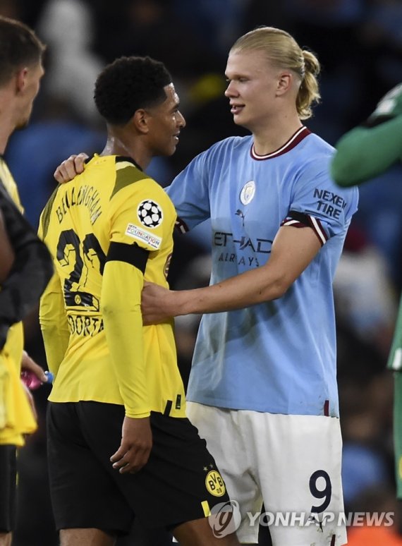 벨링엄(왼쪽)과 포옹하는 홀란 epa10184857 Erling Haaland (R) of Manchester City talks with Jude Bellingham (L) of Dortmund after winning the UEFA Champions League group G soccer match between Manchester City and Borussia Dortmund in Manchester, Britain, 14 September 2022. EPA/PETER POWELL