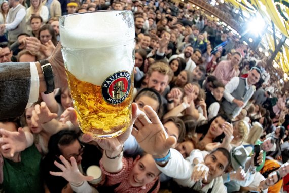 지난 9월17일(현지시간) 독일 뮌헨에서 열린 187회 옥토버페스트 행사장에서 시민들이 무료로 제공되는 맥주를 갖기위해 손을 내밀고 있다.EPA연합뉴스