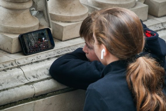 19일 오전(현지시간) 영국 런던 웨스트민스터 사원 인근에서 어린이들이 엘리자베스 2세 여왕 국장 생중계를 스마트폰으로 보고 있다.<div id='ad_body3' class='mbad_bottom' ></div> 2022.9.19/뉴스1 ⓒ News1 안은나 기자