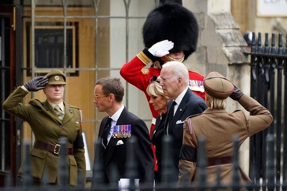 조 바이든 미국 대통령 부부가 19일(현지시간) 영국 웨스트민스터 사원에서 열린 엘리자베스 2세 장례식에 무공훈장 수상자에 뒤를 따라 입장하고 있다. AP연합뉴스