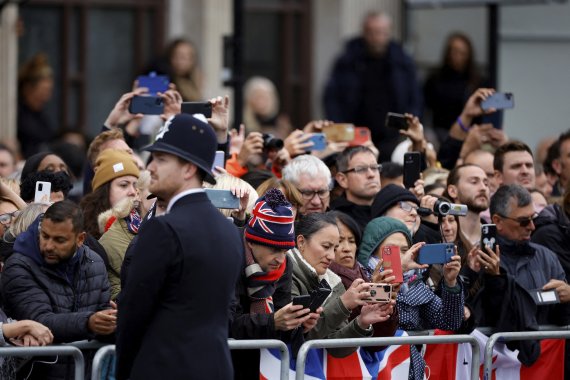 [런던=AP/뉴시스] 19일 오전 (현지시간) 영국 런던에서 고 엘리자베스 2세 영국 여왕의 추모객들이 포차(砲車)에 실려 웨스트민스터 사원으로 운구될 여왕을 기다리고 있다. 2022.09.19.