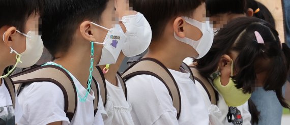20일 광진구 어린이대공원에 마스크를 쓴 어린이들이 앉아 있다. 영유아부터 마스크 완전해제를 검토하고 있다. /연합뉴스