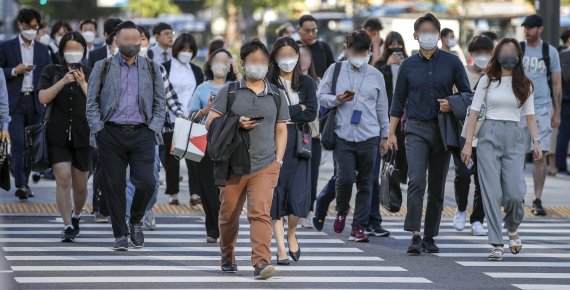 지난 21일 오전 서울 종로구 광화문네거리 인근에서 긴팔을 입은 시민들이 실외에서도 마스크를 착용한 채 이동하고 있다. 뉴시스 제공.