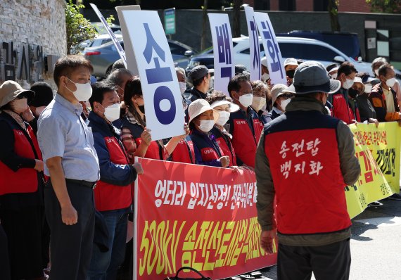 한국전력공사가 추진하는 동해안∼신가평 500㎸ 직류 장거리 송전망(HVDC) 건설사업에 반대하는 강원도 지역 주민들이 2022년 9월 21일 서울 종로구 감사원 앞에서 강원도송전탑반대대책위원회 주최로 열린 주민감사청구 기자회견에서 손팻말을 들고 있다. /연합뉴스