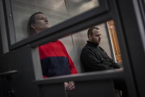 [코텔바=AP/뉴시스] 26일(현지시간) 우크라이나 북동부 코텔바에서 열린 2차 전범 재판에 러시아 군인 알렉산드르 블라디미로비치 보비킨(왼쪽)과 알렉산드르 알렉세이비치 이바노프가 출석해 있다. 우크라이나 검찰은 전쟁 범죄로 기소된 두 사람에게 각각 징역 12년을 구형했다. 2022.05.26.
