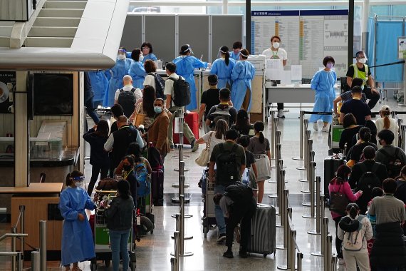 [홍콩=AP/뉴시스] 23일 홍콩 국제공항 입국장에서 승객들이 격리 호텔로 향하는 버스를 기다리고 있다. 존 리 홍콩 행정장관은 오는 26일부터 홍콩 입국자에 대한 호텔 격리 규정을 폐지한다고 밝혔다. 2022.09.23