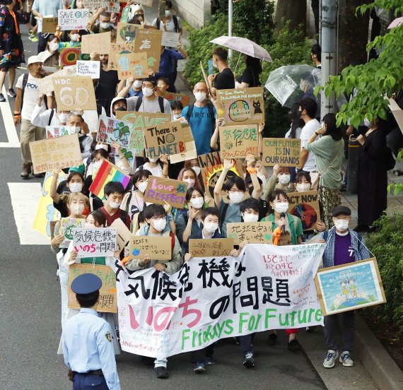 [도쿄=AP/뉴시스] 일본 도쿄 시내에서 23일 환경운동가들이 지구온난화에 반대하는 시위를 펼치고 있다. 2022.09.23