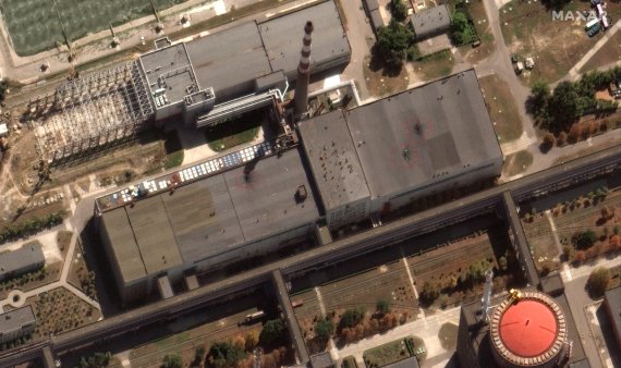 [자포리자=AP/뉴시스] 러시아는 29일(현지시간) 우크라이나군의 포격으로 자포리자 원전의 연료저장고 건물 지붕에 구멍이 뚫렸다고 밝혔다. 빨간색 원 안의 흔적이 포격으로 발생한 구멍으로 추정되는 곳이다. 사진은 자포리자 원전 원자로에 인접한 건물에 생긴 구멍을 보여주는 위성사진(Maxar Technologies 제공). 2022.08.30