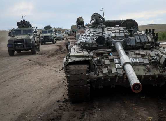 우크라이나 군인들이 24일(현지시간) 러시아군이 버리고 도망친 전차가 널부러져 있는 하르키우 지역을 차량을 타고 이동하고 있다. 우크라이나 전쟁은 올해 전세계 인플레이션(물가상승)을 악화시켜 세계 경제에 경기침체 먹구름을 몰고 오고 있다. 로이터연합