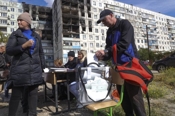 [도네츠크=AP/뉴시스] 지난 24일(현지시간) 우크라이나 동부 친러 성향의 도네츠크인민공화국(DPR)에서 합병을 위한 주민투표가 진행 중이다. 현지 주민들이 투명 투표함에 기표한 투표용지를 넣고 있다. 2022.09.24. /사진=뉴시스