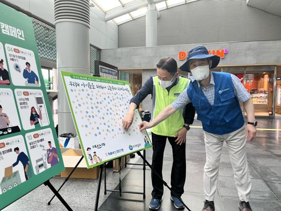 NH농협은행 김춘안 부행장(왼쪽)과 한국환경공단 안병옥 이사장이 지난 23일 검암역에서 온실가스 감축을 위한 시민 참여 캠페인을 실시하고 있다. NH농협은행 제공