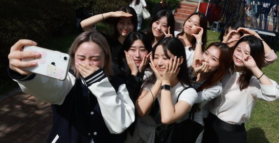 실외 마스크 착용 의무가 전면 해제된 26일 서울 숙명여자대학교에서 열린 축제 '청파제'에 참여한 학생들이 기념촬영을 하고 있다. /연합뉴스