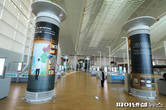 지난 26일 인천공항 제2여객터미널을 방문한 여객들이 공조타워 지역에 전시된 참가작품의 글귀를 감상하고 있다. 인천국제공항공사 제공