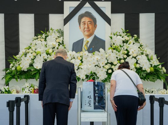 27일 오전 아베 신조 일본 총리의 국장을 앞두고 일본 도쿄의 일본무도관 밖에 마련된 분향소에서 영정 앞에 선 조문객들이 애도하는 마음을 담아 마지막 인사를 하고 있다. 사진=뉴스1