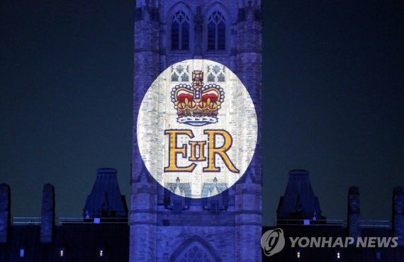 엘리자베스 2세 여왕의 문장 Queen Elizabeth's Royal Cypher is projected on the Peace Tower of the Parliament Buildings, after Queen Elizabeth's passing, in Ottawa, Ontario, Canada, September 8, 2022. REUTERS/Patrick Doyle