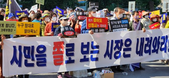 대구 달서구민들이 9월 30일 오전 대구시청 동인청사 주차장에서 시청사 바로세우기 시민연대 주최로 열린 '시청사 부지 일부 매각 철회 및 조속한 청사 건립 촉구 대회'에서 피켓과 플래카드를 들고 구호를 외치고 있다. 사진=김장욱 기자