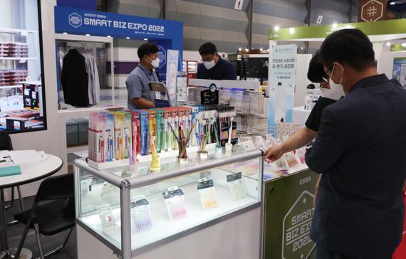 중소기업의 판로 개척을 돕기 위한 '2022 스마트비즈엑스포'가 4일 서울 코엑스에서 열린 가운데 참가자들이 스마트공장 시스템으로 생산된 제품을 살피고 있다. 사진=박범준 기자