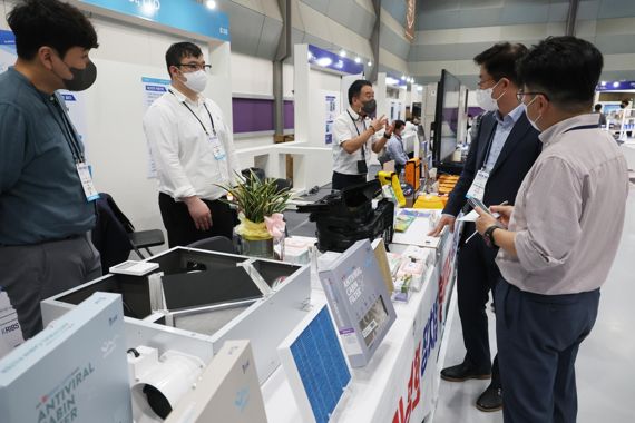 중소기업의 판로 개척을 돕기 위한 '2022 스마트비즈엑스포'가 4일 서울 코엑스에서 열린 가운데 참가자들이 스마트공장 시스템으로 생산된 제품을 살피고 있다. 사진=박범준 기자