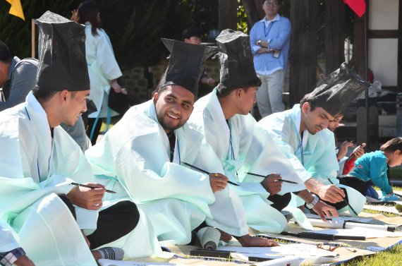 【울산=뉴시스】배병수 기자 = 한글날인 9일 울산시 중구 동헌에서 열린 2019 한글문화예술제 한글 과거제에 참가한 외국인들이 성균관 유생 복장을 한 채 '한글'이라는 시제에 맞춰 2행시를 짓고 있다. 2019.10.09. bbs@newsis.com