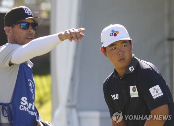 2라운드 10번 홀 앞두고 캐디와 상의하는 김주형 Tom Kim, right, of South Korea, consults with his caddie before teeing off at the 10th hole for par during the second round of the Shriners Children's Open golf tournament at TPC Summerlin, Friday, Oct. 7, 2022, in Las Vegas. (AP Photo/Ronda Churchill)