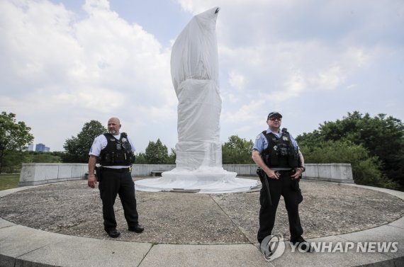 훼손당한 콜럼버스 동상을 지키는 시카고 경찰 epa08496625 Chicago police officers stand guard at a defaced statue of Christopher Columbus during a Juneteenth protest rally and march for Defend Black Lives in Chicago, Illinois, USA, 19 June 2020. Juneteenth, or 19 June, is recognized as the day in 1865 that word of the E