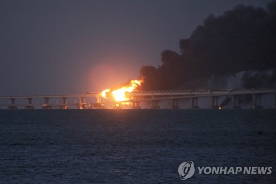 일부 붕괴된 크림대교 Flame and smoke rise from the Crimean Bridge connecting Russian mainland and the Crimean peninsula over the Kerch Strait, in Kerch, Crimea, early Saturday, Oct. 8, 2022. Russian authorities say a truck bomb has caused a fire and the partial collapse of a bridge linking Russia-annexed Cri