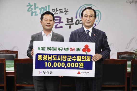 박상돈 충남시장군수협의회장(오른쪽)이 14일 박정현 부여군수에게 재난 의연금을 전달하고 기념촬영을 하고 있다.