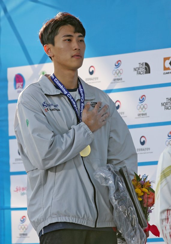 대한민국 이승범이 14일 오후 서울 서초구 잠원한강공원에서 열린 2022 국제스포츠클라이밍연맹(IFSC) '서울 스포츠클라이밍 아시아선수권대회' 남자 스피드 부문 시상대에 올라 금메달을 목에 걸고 국기에 대한 경례를 하고 있다. 2022.10.14/뉴스1 ⓒ News1 이승배 기자