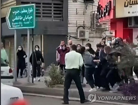 시위하는 이란인들 TOPSHOT - This image grab from a UGC video made available on October 12, 2022 shows female protesters being roughly handled by Iranian security forces in the city of Rasht, in Iran's northern Gilan province. - Protests have erupted in cities around the globe, since 22-year-old Iranian woma