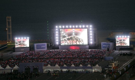 [부산=뉴시스] 하경민 기자 = 2030부산월드엑스포 유치 기원 BTS콘서트 '옛 투 컴 인 부산'(Yet to Come in BUSAN)이 열린 15일 부산 동구 부산항국제여객터미널 야외주차장에 마련된 '라이브 플레이' 행사장을 찾은 1만여 명의 '아미'들이 콘서트를 생중계로 즐기고 있다. 2022.10.15. yulnetphoto@newsis.com