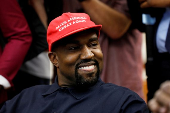 미국 래퍼 카녜이 웨스트(예)가 2018년 10월 11일 워싱턴 백악관에서 도널드 트럼프 당시 대통령이 주최한 한 행사에 참석해 "미국을 더 위대하게"라는 트럼프의 선거구호사 담긴 모자를 쓰고 웃고 있다. 로이터연합