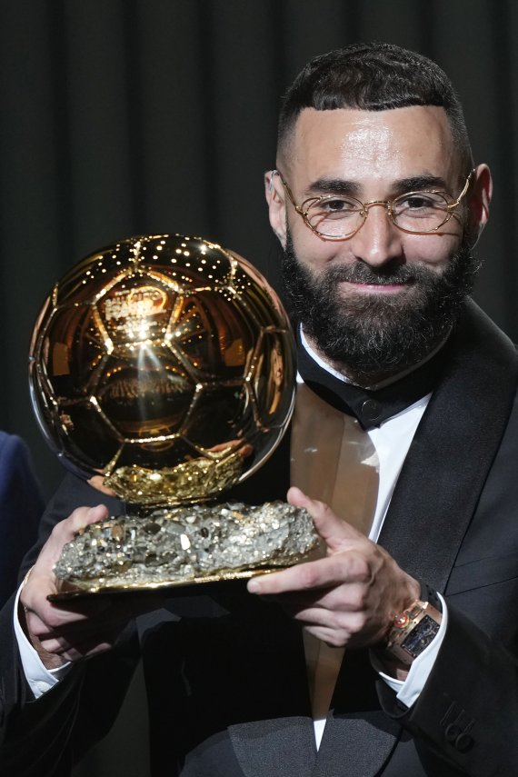 [파리=AP/뉴시스] 카림 벤제마(레알 마드리드)가 17일(현지시간) 프랑스 파리의 샤텔레 극장에서 열린 제66회 발롱도르 시상식에서 남자 발롱도르 트로피를 받고 포즈를 취하고 있다. 벤제마는 지난 시즌 라리가 32경기 27골 12도움으로 리그 득점왕, 챔피언스리그에서도 12경기 15골로 득점왕을 차지했다. 2022.10.18.