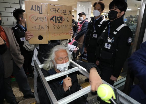 [서울=뉴시스] 김금보 기자 = 박경석 전국장애인차별철폐연대 대표가 19일 오전 서울 서초구 교대역 2호선 승강장에서 '제40차 출근길 지하철 탑니다' 시위를 하고 있다. 2022.10.19. kgb@newsis.com