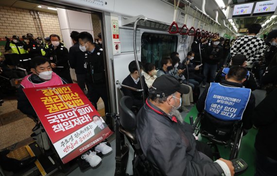 [서울=뉴시스] 김금보 기자 = 전국장애인차별철폐연대 활동가들이 19일 오전 서울 서초구 교대역 2호선 승강장에서 '제40차 출근길 지하철 탑니다' 시위를 하고 있다. 2022.10.19. kgb@newsis.com