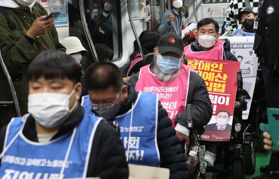 [서울=뉴시스] 김금보 기자 = 전국장애인차별철폐연대 활동가들이 19일 오전 서울 서초구 교대역 2호선 승강장에서 전동차에 탑승, '제40차 출근길 지하철 탑니다' 시위를 하고 있다. 2022.10.19. kgb@newsis.com