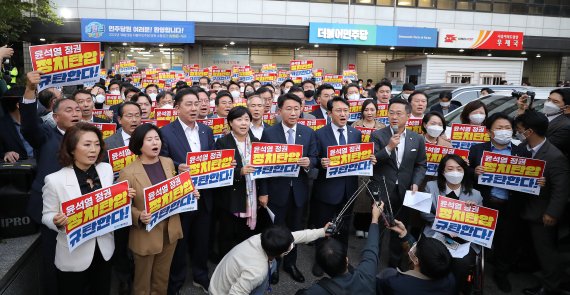 더불어민주당 국회의원들이 19일 서울 여의도 더불어민주당사 앞에서 검찰 압수수색과 관련해 정치탄압을 규탄하는 구호를 외치고 있다. 검찰은 이날 정치자금법 위반 혐의로 체포된 김용 민주연구원 부원장과 관련해 더불어민주당사 내에 위치한 민주연구원 압수수색에 나섰다. 뉴시스.