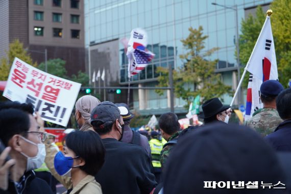 22일 중구 태평로 일대에서 진보세력의 '윤석열 퇴진' 손 팻말과 보수세력의 태극기·성조기가 공존하고 있다./사진=김동규 기자