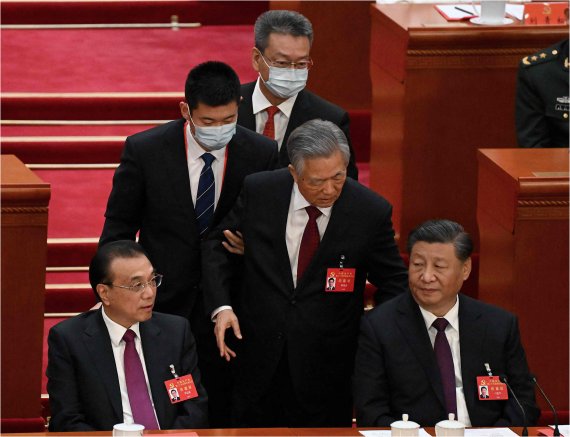 퇴장하는 후진타오. 지난 22일 중국 베이징 인민대회당에서 열린 중국 공산당 20차 전국대표대회(당 대회) 폐막식 도중 돌연 후진타오 전 주석(오른쪽 두번째)이 수행원의 부축을 받고 퇴장하며 시진핑 주석에게 무언가 말을 건네고 있다. AFP연합뉴스