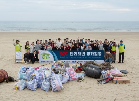 지난 21일 충남 보령시 원산도해수욕장에서 SGC솔루션 임직원들과 국제구호개발NGO 휴먼인러브 관계자들이 해안 정화 활동 후 기념촬영을 하고 있다. SGC솔루션 제공.