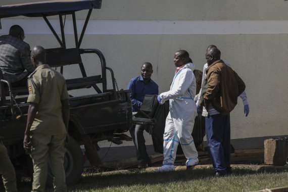 [캄팔라(우간다)=AP/뉴시스]화재가 발생해 11명의 어린 학생들이 숨진 우간다 무코노 지역 루가 마을의 살라마 시각장애인학교 화재 현장에서 25일 보안군이 희생자의 시신을 담은 시체운반용 부대를 옮기고 있다. 숨진 11명 외에 6명이 중태에 빠져 병원에 입원했다. 2022.10.25