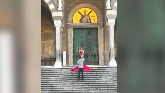 지난 17일 오전 한 여성 관광객이 이탈리아 아말피의 성 안드레아 대성당 앞에서 붉은색 천으로 몸의 일부만 가린채 포즈를 취하고 있는 모습. 출처=아말피노티즈 페이스북, SBS