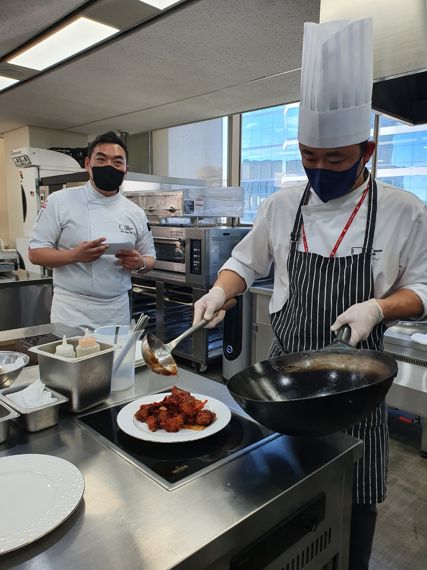 지난 25일 서울 송파구 롯데마트 본사 푸드이노베이션센터(FIC)서 열린 쿠킹쇼에서 전중훈 중식셰프(오른쪽)가 쿵파오 치킨을 조리한 후 접시에 담고 있다. / 사진=이정은 기자