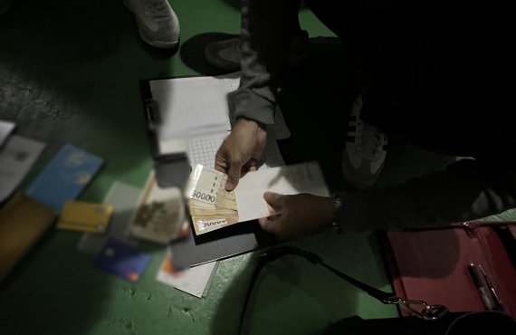 지난 13일 경찰이 울산 삼산동 성매매 업소 현장에서 현금과 장부 등을 압수하고 있다. (울산경찰청 제공)