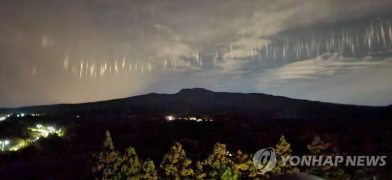 한라산 위 빛기둥 (제주=연합뉴스) 26일 오후 제주 서귀포시에서 바라본 하늘에 빛기둥이 나타난 모습. 제주지방기상청은 이에 대해 "제주도 앞바다에서 조업하는 어선들의 밝은 집어등 빛이 5∼6㎞ 높이 상층운에 의해 반사돼 관측되는 현상"이라고 설명했다. 2022.10.26 [난대아열대산림연구소 제공. 재판매 및 DB 금지] atoz@yna.co.kr (끝) /사진=연합뉴스