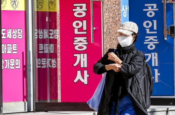 국회가 추진중인 공인중개사법 개정안으로 한국공인중기사협회와 신생 업체간 갈등이 커지고 있다. 25일 서울시내 공인중개업소 앞에서 시민들이 이동중인 모습. /사진=뉴시스